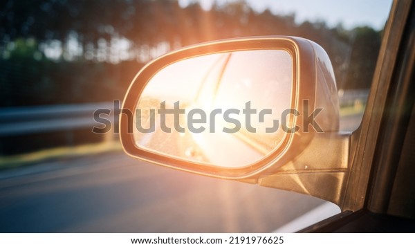 Road trip car mirror. Sun, highway\
car road reflection in mirror. Summer holidays trip\
concept