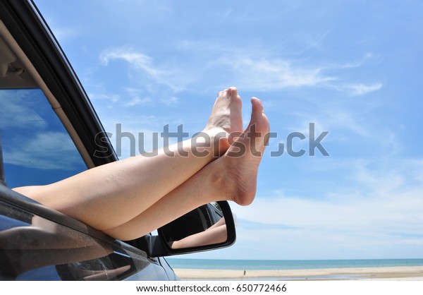 road trip car vacation concept. Woman legs out of\
the car window