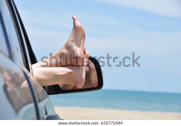 road trip car vacation concept. Woman legs out of\
the car window