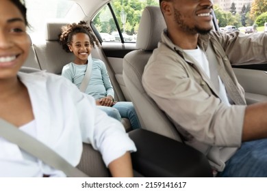 Road Trip. Cheerful Black Family Riding New Car Travelling Together By Auto In Summer. Cropped Shot, Selective Focus On Happy Little Girl On Sitting On Back Seat In Automobile