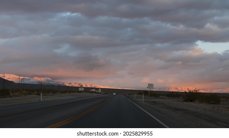 Road Trip, Driving Auto From Death Valley To Las Vegas, Nevada USA. Hitchhiking Traveling In America. Highway Journey, Dramatic Atmosphere, Sunset Mountain And Mojave Desert Wilderness. View From Car.