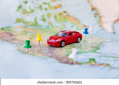 Road Trip At Homeland - Red Car Goes On Map Across Territory Of USA. Route Of Automobile Travel Is Laid On By Office Buttons. Domestic Tourism.