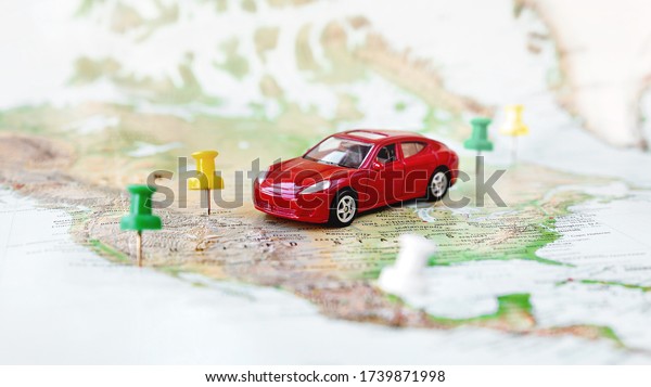 Road trip at homeland - red car goes on map\
across territory of USA. Route of automobile travel is laid on by\
office buttons. Domestic\
tourism.