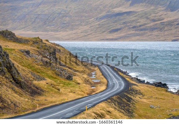 Road\
trip in Iceland empty coast road curving along\
fjord