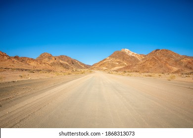 Road trip on gravel roads between mountains to Ai-Ais, Namibia.
