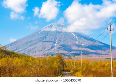 Road Trip And See Beautiful Active Volcano Of Mount Yotei. Active Volcano Of Mt. Totei In Hokkaido, Japan. Golden Forest In The Autumn With Volcano Background In The Back. 