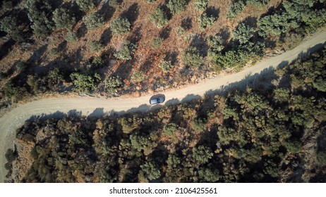 Road Trip, Top View Of Car On Curvy Dirt Road, Drone Shot From The Top Of The Car Driving On A Dirt Road Surrounded By Trees