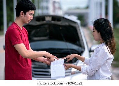 road trip, transport, travel and people concept - family couple with open Car manual book of broken car at countryside . - Powered by Shutterstock