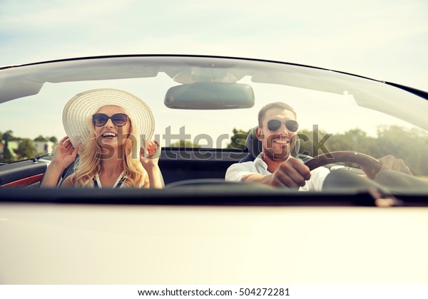 road trip,\
travel, dating, couple and people concept - happy man and woman\
driving in cabriolet car\
outdoors