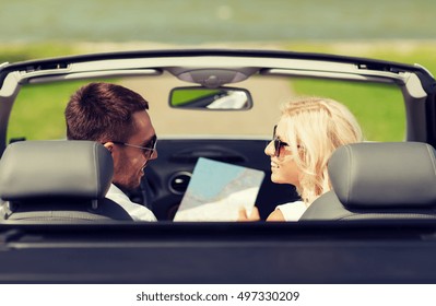 道路旅行、旅行、レジャー、カップル、および人々のコンセプト – 地図とキャブリオレットカーで運転する幸せな男女