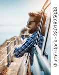 Road trip, travel and man in window of car driving for adventure, summer vacation and holiday. Transportation, relax and face of male person in motor vehicle for freedom, journey and happy by ocean