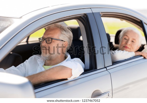 road trip, travel and old people concept - happy
senior couple driving in
car