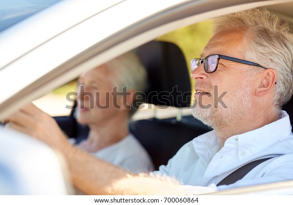 road trip, travel and old people concept - happy
senior couple driving in
car