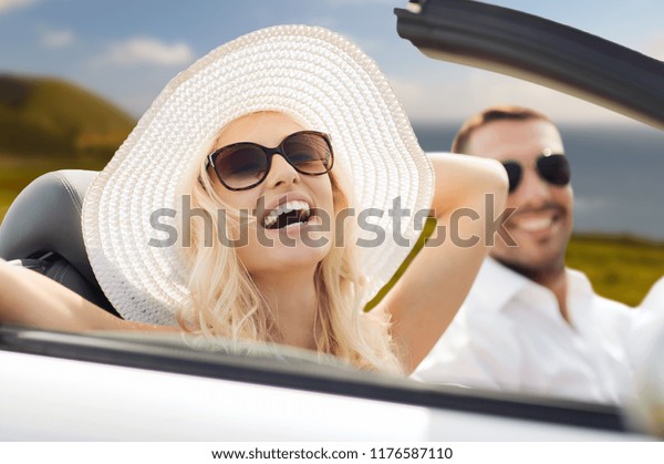 road trip, travel and people concept - happy\
couple driving in convertible car outdoors over big sur coast of\
california background