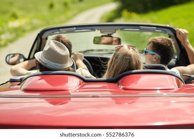 road trip, travel, vacation and people concept - happy friends driving in convertible car at summer