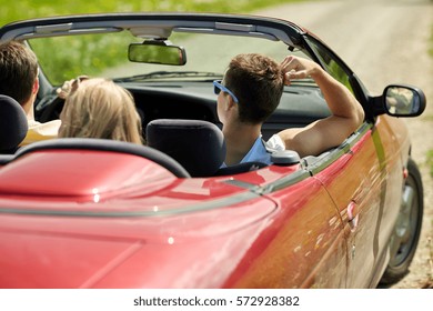 Road Trip, Travel, Vacation And People Concept - Happy Friends Driving In Convertible Car At Summer