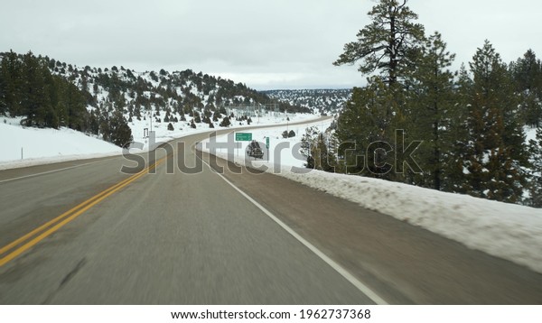 Road trip in USA from Zion to Bryce Canyon, driving\
auto in Utah. Hitchhiking traveling in America, Route 89 to Dixie\
Forest. Winter local journey, calm atmosphere and snow mountains.\
View from car.