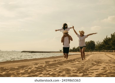 Road trips day. Happy family people having fun in summer vacation on beach, daughter riding on father back and mother running race at sand beach, enjoying road family trip playing together outdoor - Powered by Shutterstock