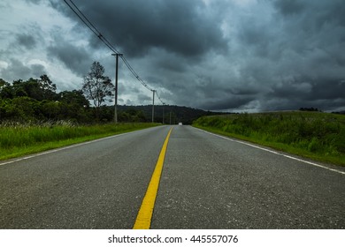 Road under dark storm clouds.
