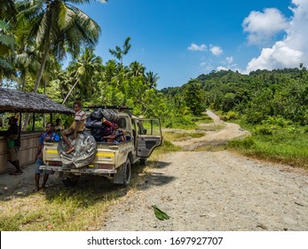 Road From VANIMO To AITAPE, PAPUA NEW GUINEA - 10/10/2019: Local Road And Local Transport In Island Of New Guinea, Leads Through The Jungle,  Pick-up Car With Local People 