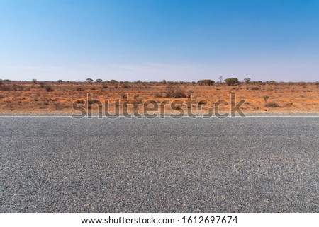 The road view with red dirt at the background and blue sky at outback rural of New South wales, Australia.