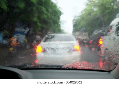 Road view through car window with rain drops, Driving in rain.