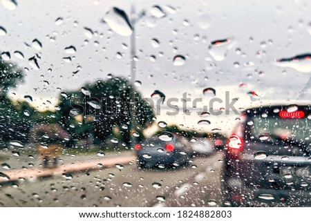 Road view through car window blurry with heavy rain, Concept of driving in rain, bad driving conditions.