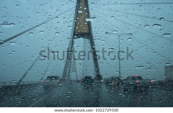 Road view\
through car window blurry with heavy rain, Driving in rain, rainy\
weather, rainy day, rain\
background