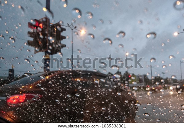 Road view through car\
window blurry with heavy rain, Concept of driving in rain, bad\
driving conditions\
\
