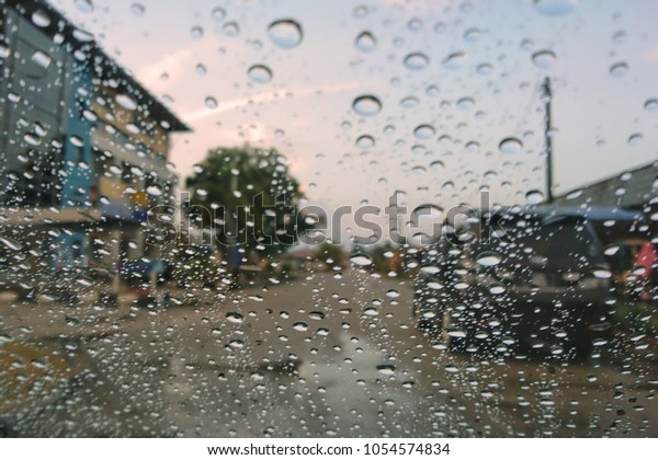 Road view through car window blurry with\
heavy rain, Driving in rain, rainy weather.\
