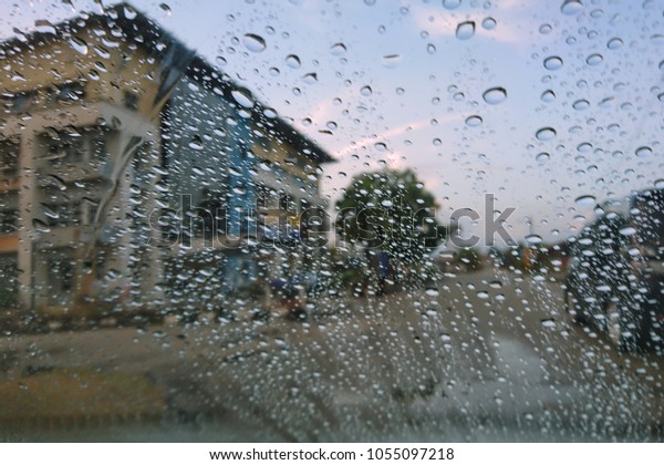Road view through car window blurry with\
heavy rain, Driving in rain, rainy weather.\
