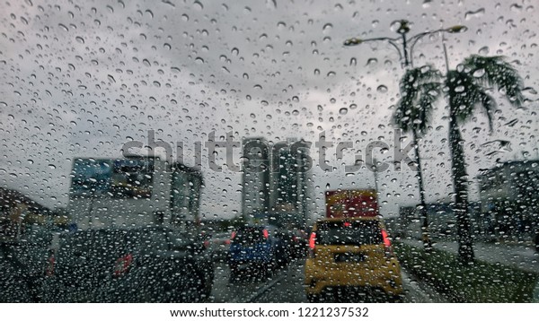 Road view\
through car window blurry with heavy rain, Driving in rain, rainy\
weather, rainy day, rain\
background.