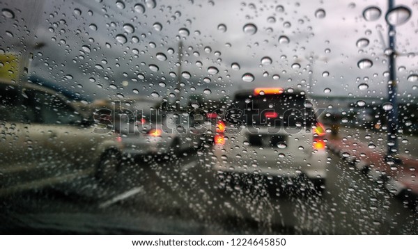 Road view through car\
window blurry with heavy rain, Concept of driving in rain, bad\
driving conditions