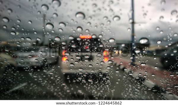 Road view through car\
window blurry with heavy rain, Concept of driving in rain, bad\
driving conditions