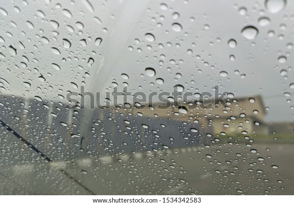 Road view through car\
window blurry with heavy rain, Concept of driving in rain, bad\
driving conditions.