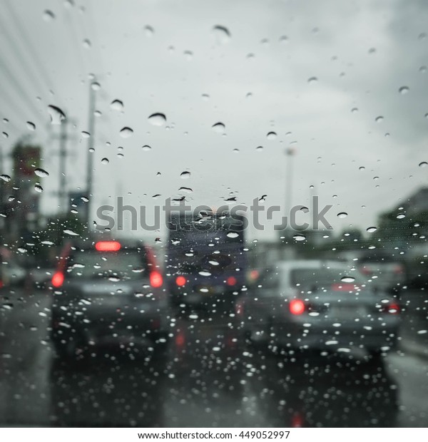Road view through car window blurry with\
heavy rain, Driving in rain, rainy\
weather