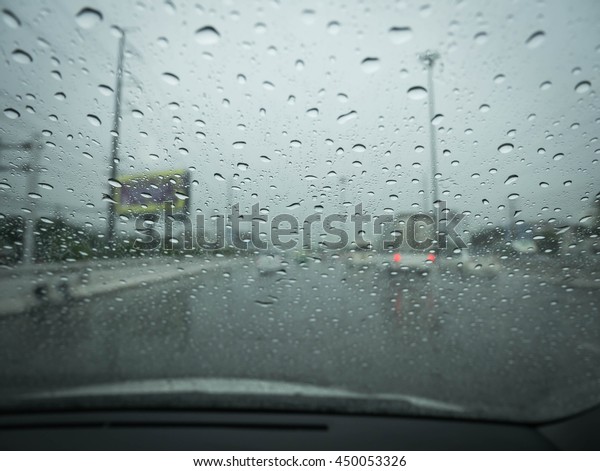 Road view through car window blurry with\
heavy rain, Driving in rain, rainy\
weather