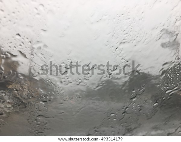 Road view through car window with\
rain drops, Driving in a heavy rain. A traffic in the heavy\
rain,View through the window and Shallow depth of field\
composition.