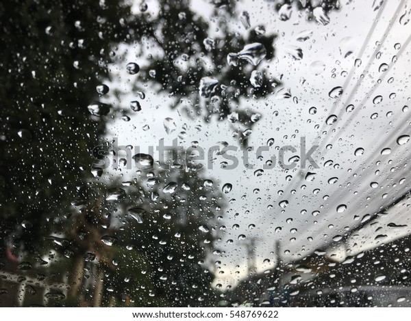 Road view through car window with rain drops, Driving
in a heavy rain. A traffic in the heavy rain,View through the
window and Shallow depth of field composition.Romantic atmosphere
on the country way