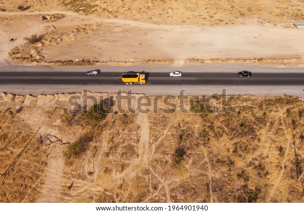 Road to wholesale market of Zhibek Zholy for sale of\
vegetables and fruits in Shymkent, South Kazakhstan aerial view.\
Bypass highway near Badam River top view. Cargo passenger cars are\
moving on road