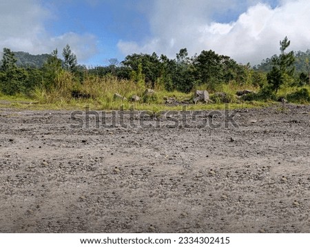 Road in wild mountains. Small rocks on the road, extreme travel adventure, blue sky with heavy cloud