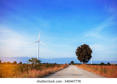 Road In The Wind Turbines Farm With The Blue Sky.