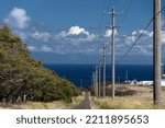 Road to windmill farm near Upolu Point with poles and cables over it, Big Island, Hawaii