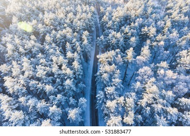 Road in a winter forest from above
