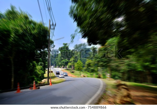 Road in the woods, driving at high speed in empty\
road- motion blur.