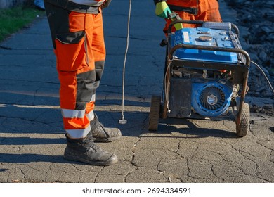A road worker prepares to start a generator with a starter actuator cord.