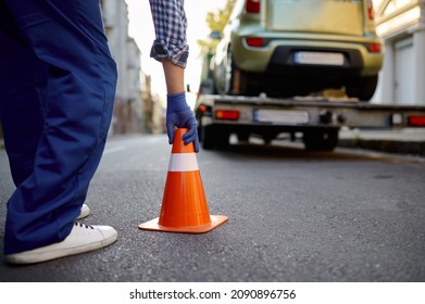 Road worker putting traffic cone on roadside