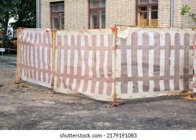 Road Works In The Courtyard Of A Residential House And Warning Fencing. Renovation Of Destroyed Asphalt And Pavement. Replacement And Repair. Paving The Street In The City. Civil Engineering Concept