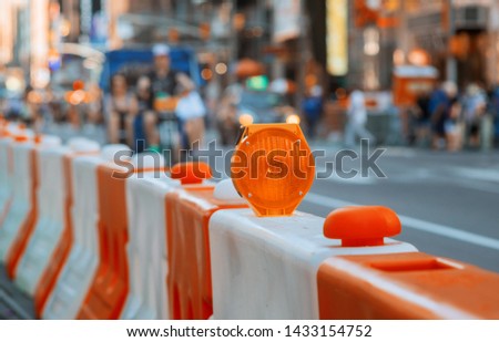 Roadblock or construction with signal on a road red and white street barricade.