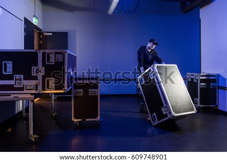 Roadie tipping a flightcase over on it's side